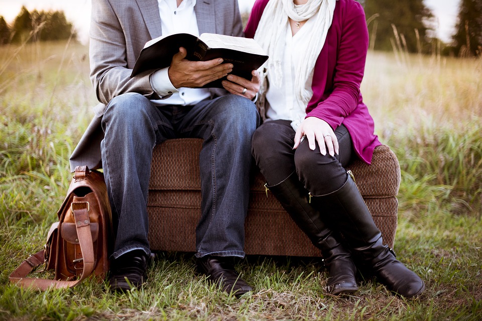 Un home i una dona llegint en un parc