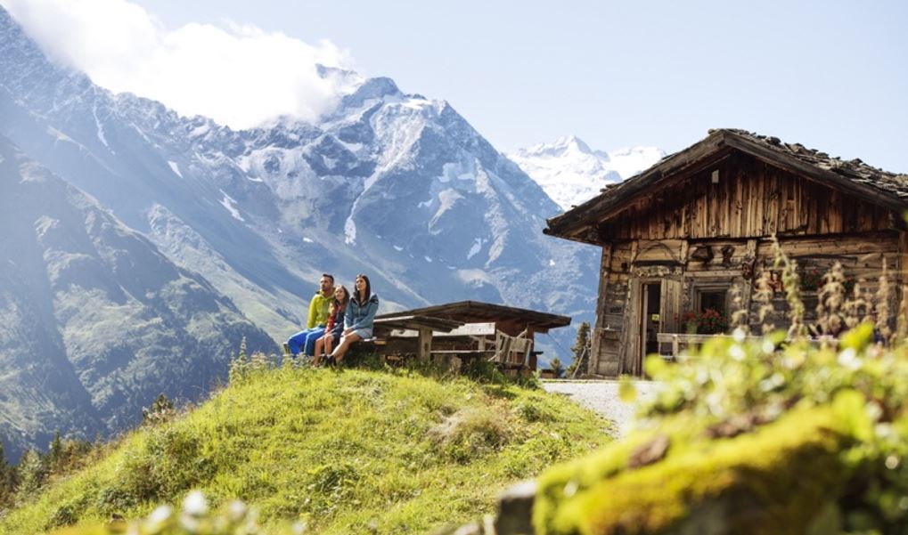 Tres persones descansant en una casa de fusta a la muntanya d'Àustria