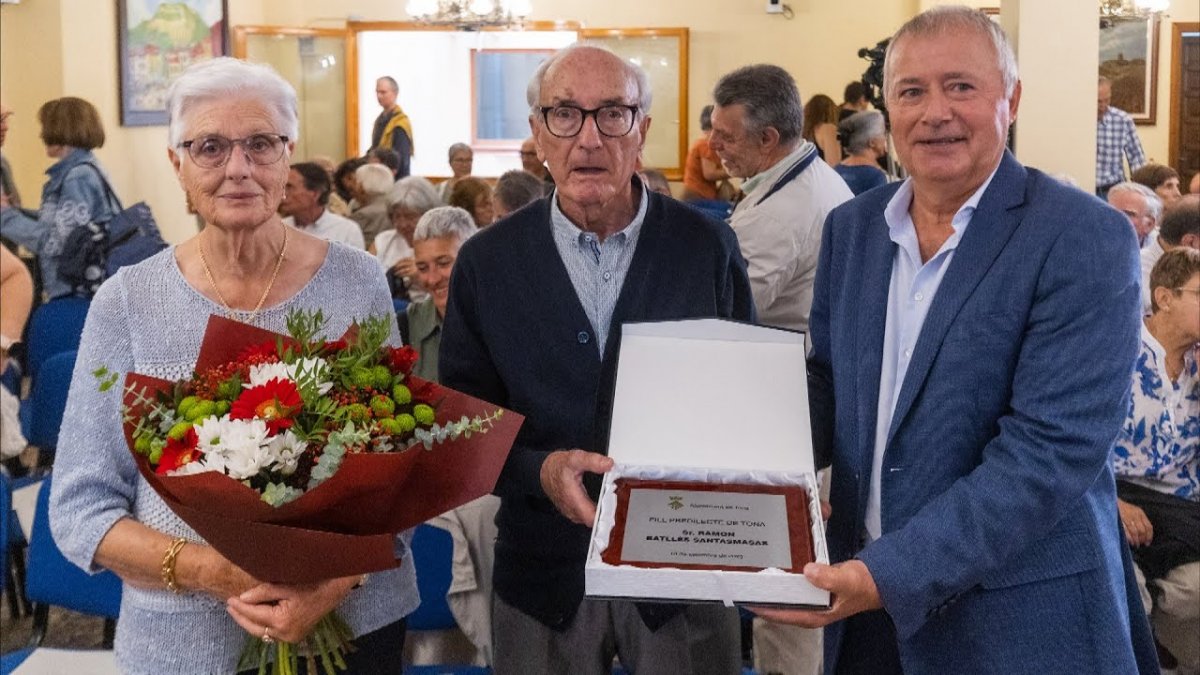 Ramon Batllés, amb la seva esposa i l'alcalde de Tona, Lluís Ges, amb la placa de reconeixement