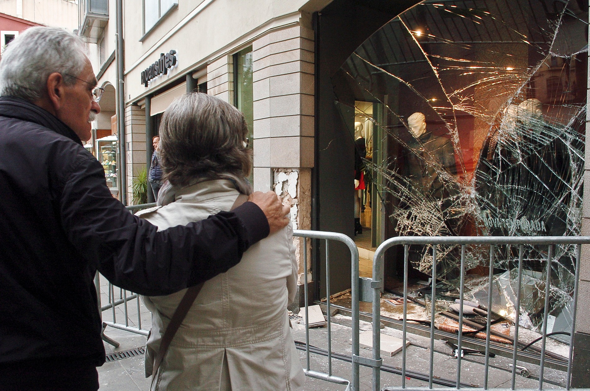 Una vianants mirant els danys que ha patit la botiga Joan Sitjes