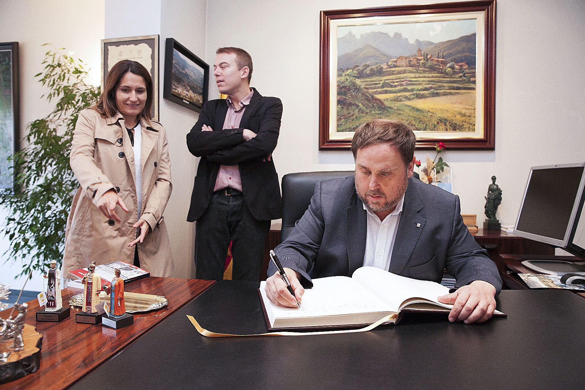 Oriol Junqueras signant el llibre d'Honor a l'Ajuntament de Manlleu, acompanyat d'Àlex Garrido i Laura Vilagrà
