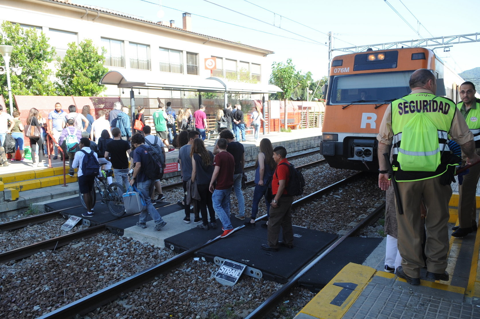 Passatgers travessant les vies a l'estació de la Garriga