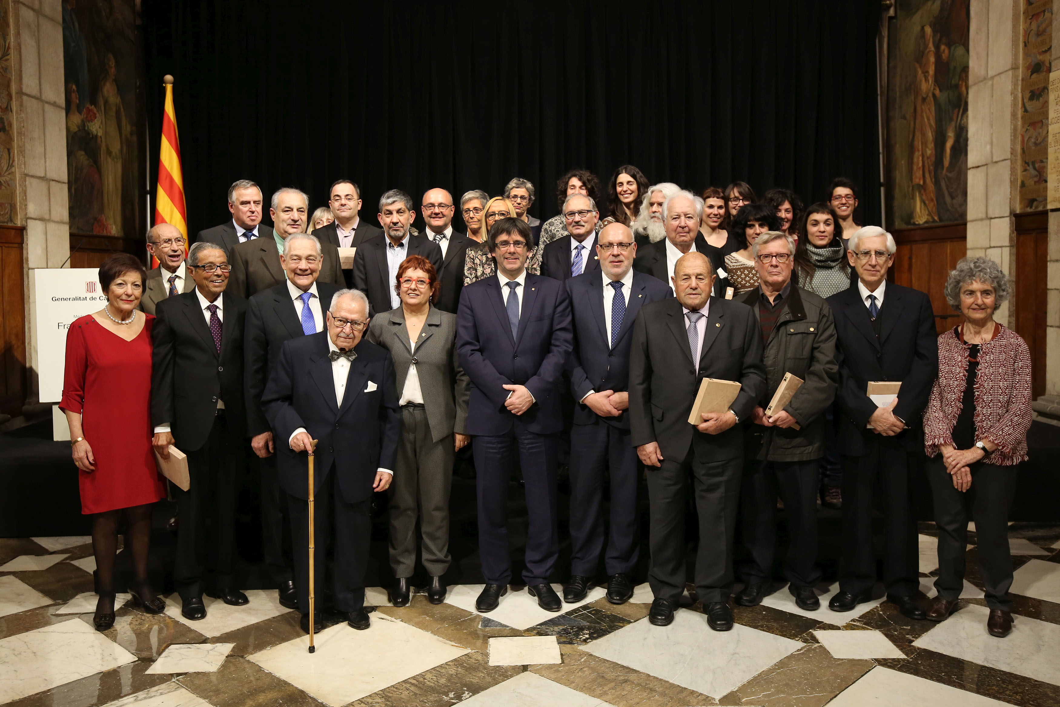 Paituví, segon per l'esquerra en primera fila, després de l'acte de lliurament del reconeixement, amb el president Carles Puigdemont i la consellera Dolors Bassa