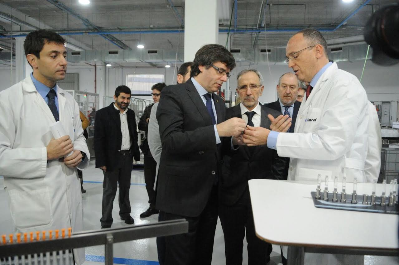 El director general de Dara Pharma, David Ral, mostra un dels processos productius de l'empresa al president Puigdemont, en presència de l'alcalde de Granollers, Josep Mayoral