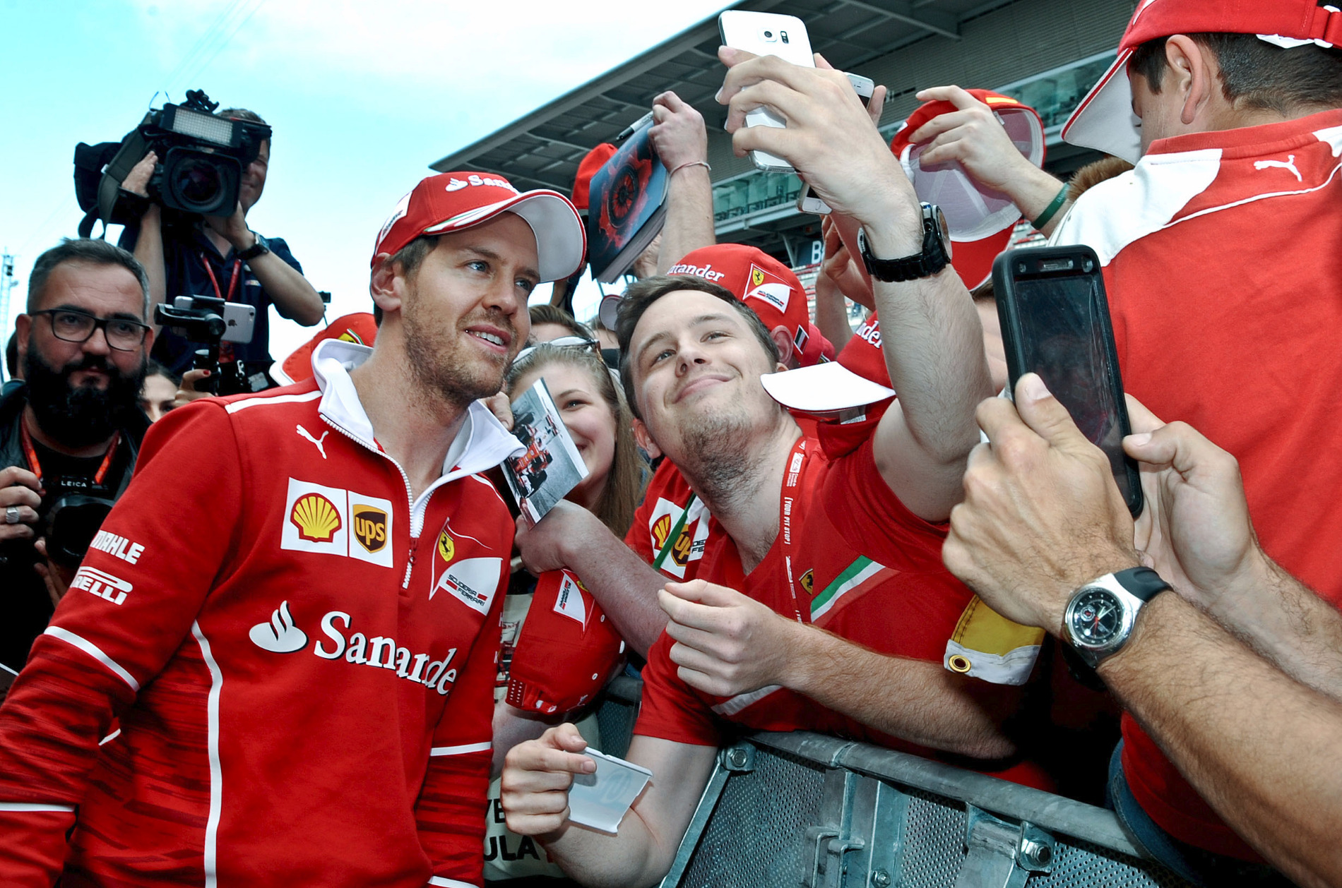 Sebastian Vettel, líder del Múndial, es fa un 'selfie' amb un aficionat, dijous durant el 'pit walk'