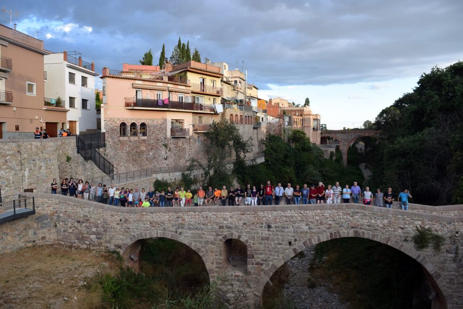 Els participants en la caminada passant pel pont romànic