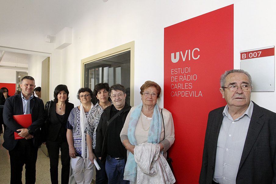 Familiars de Carles Capdevila, l'alcaldessa de Balenyà i representants de la UVic davant de les portes de l'estudi