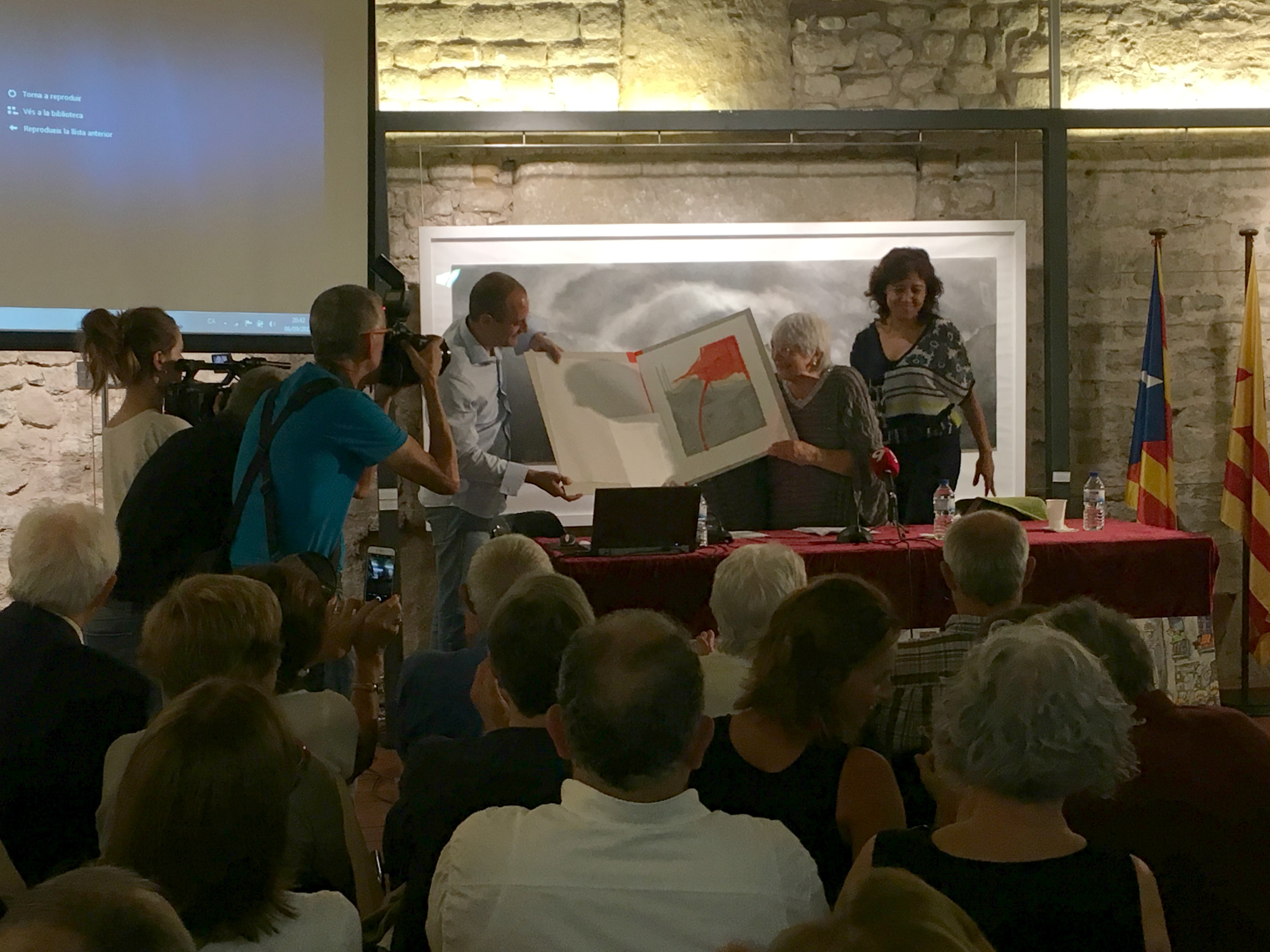 El vicepresident d'Òmnium Cultural Osona, Marc Sardà, lliura la litografia de Josep Vernis a Pilarín Bayés