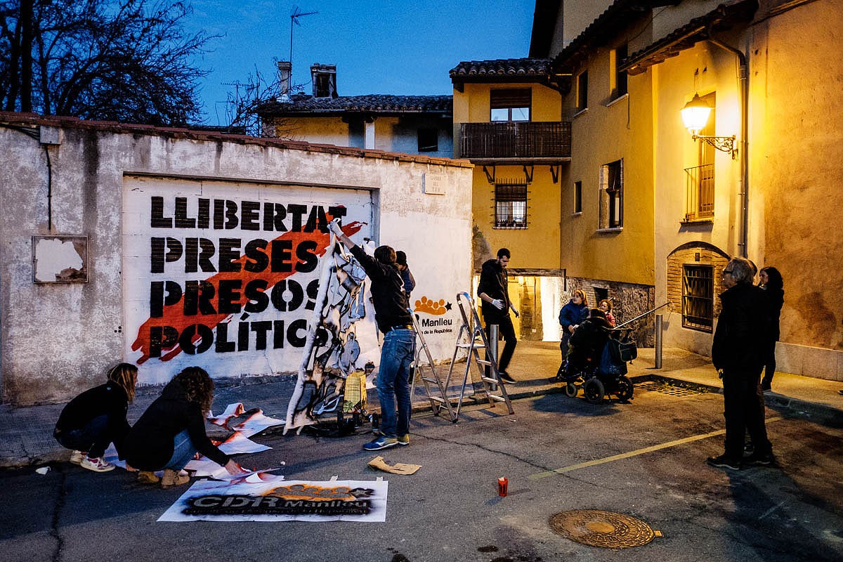 Ciutadans de Vic col·locant cartells i fent pintades a favor de la llibertat dels presos polítics