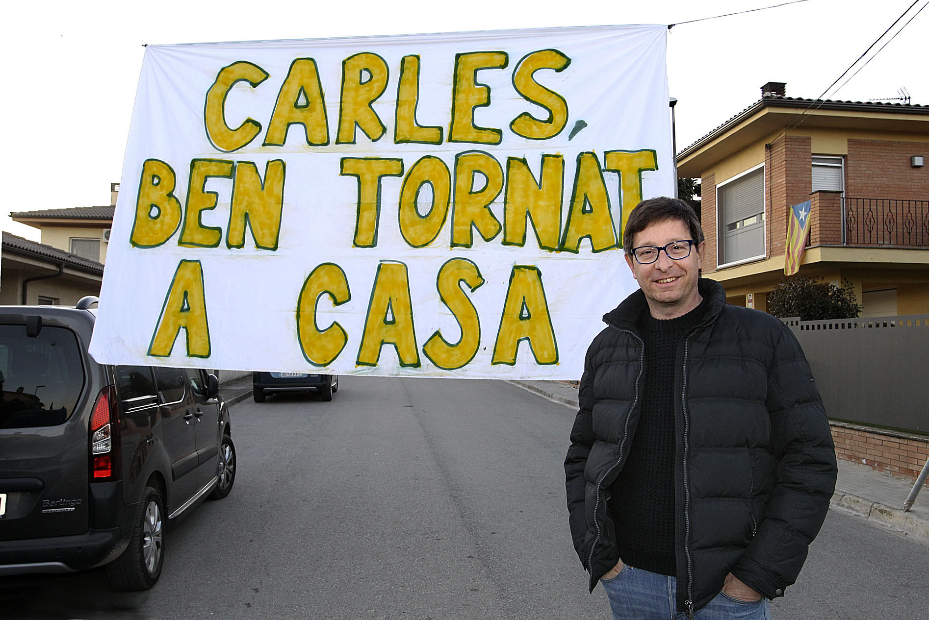 Carles Mundó davant de casa seva on els veïns li van penjar una pancarta de benvinguda