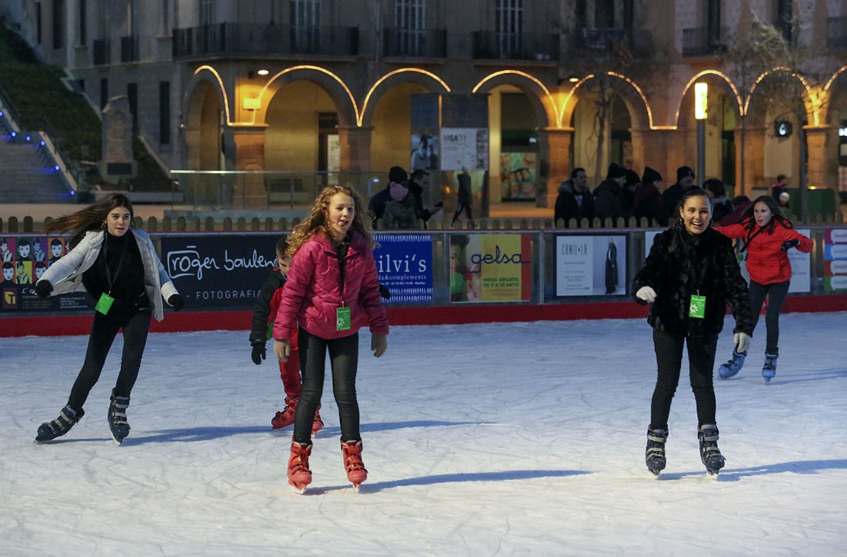 Patinadors a la pista de gel, instal·lada un any mes a la plaça Fra Bernadí