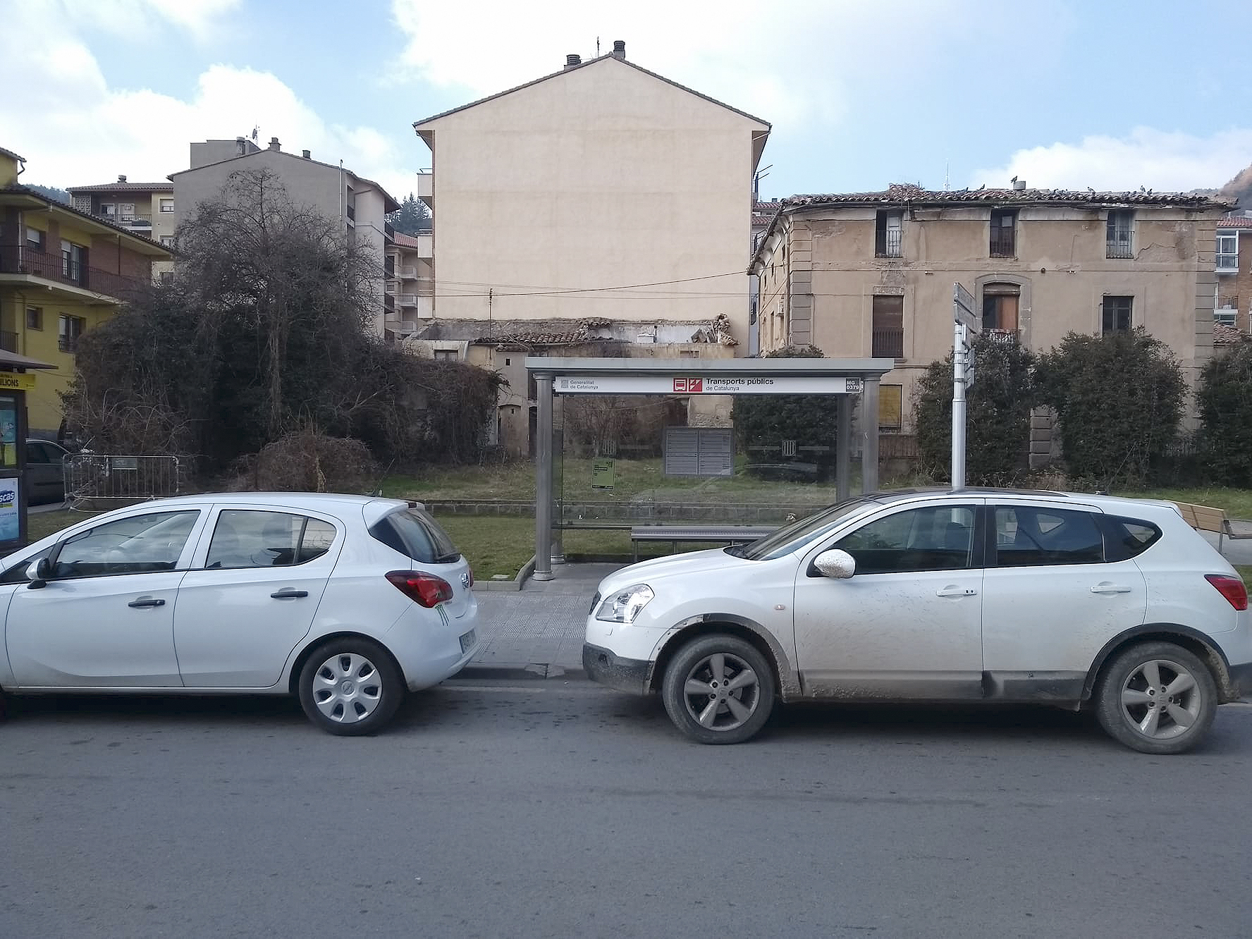 Cotxes particulars aparcats en una parada del bus a Ripoll