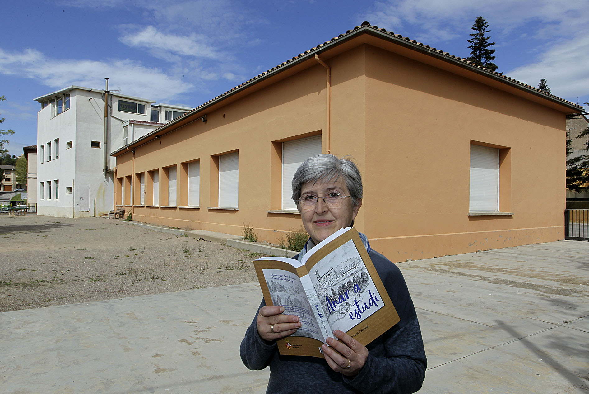 Domi Correas, amb un exemplar del llibre, davant l'escola d'Olost