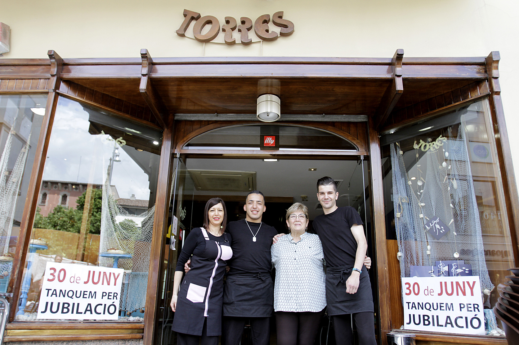 Roser Alarcón amb els treballadors de l'establiment a les portes de la pastisseria, on ja se n'anuncia el tancament