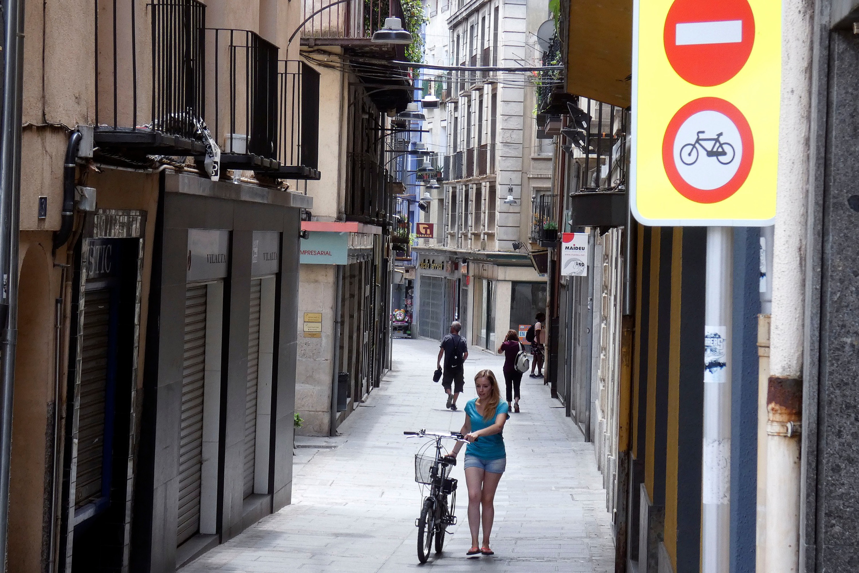 Una noia amb bici, a peu, al carrer Sant Pere