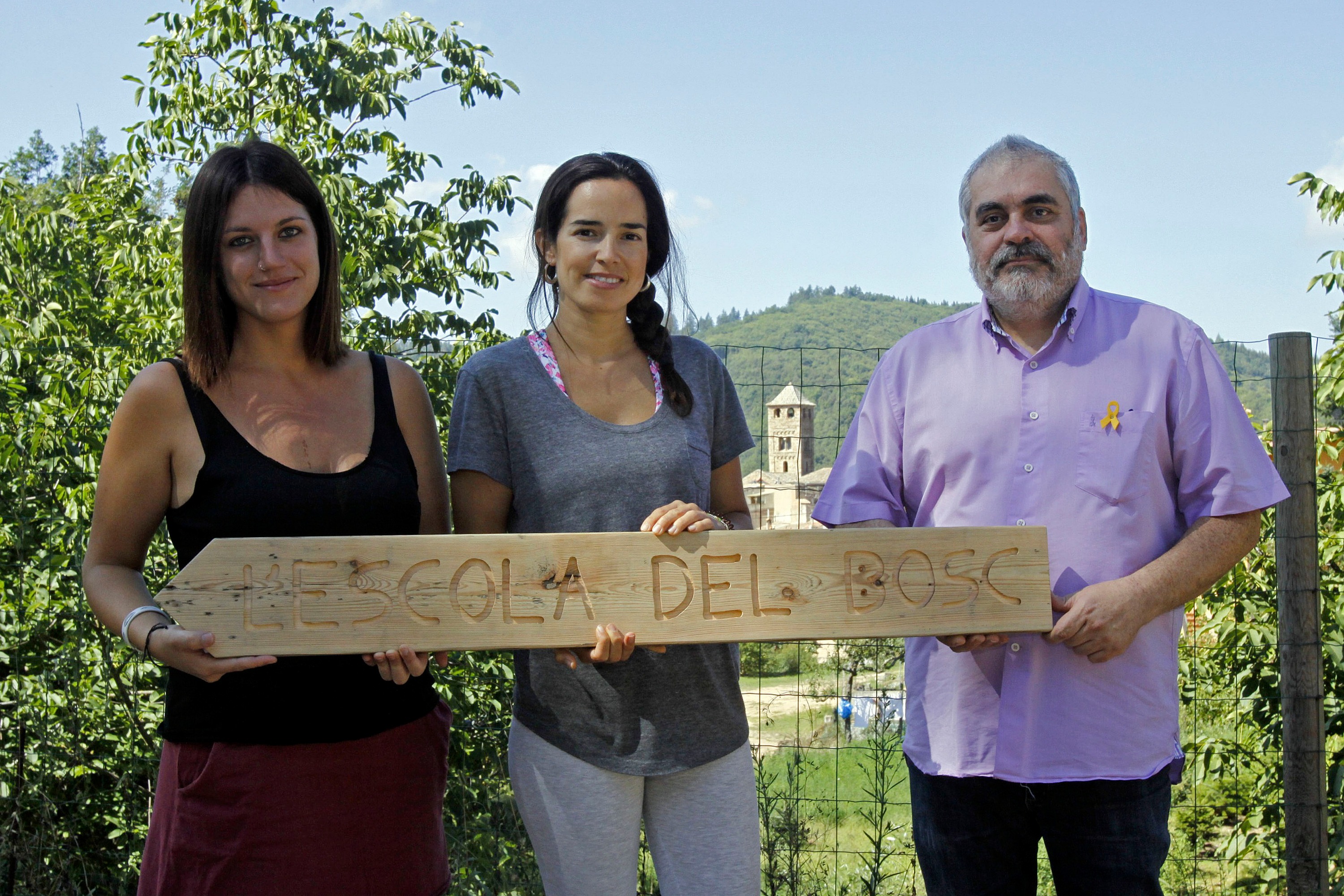 Es educadores de l'Escola del Bosc, Iria Comajoan i Clara Barba, i l'alcalde d'Espinelves Joan Manuel Claveria