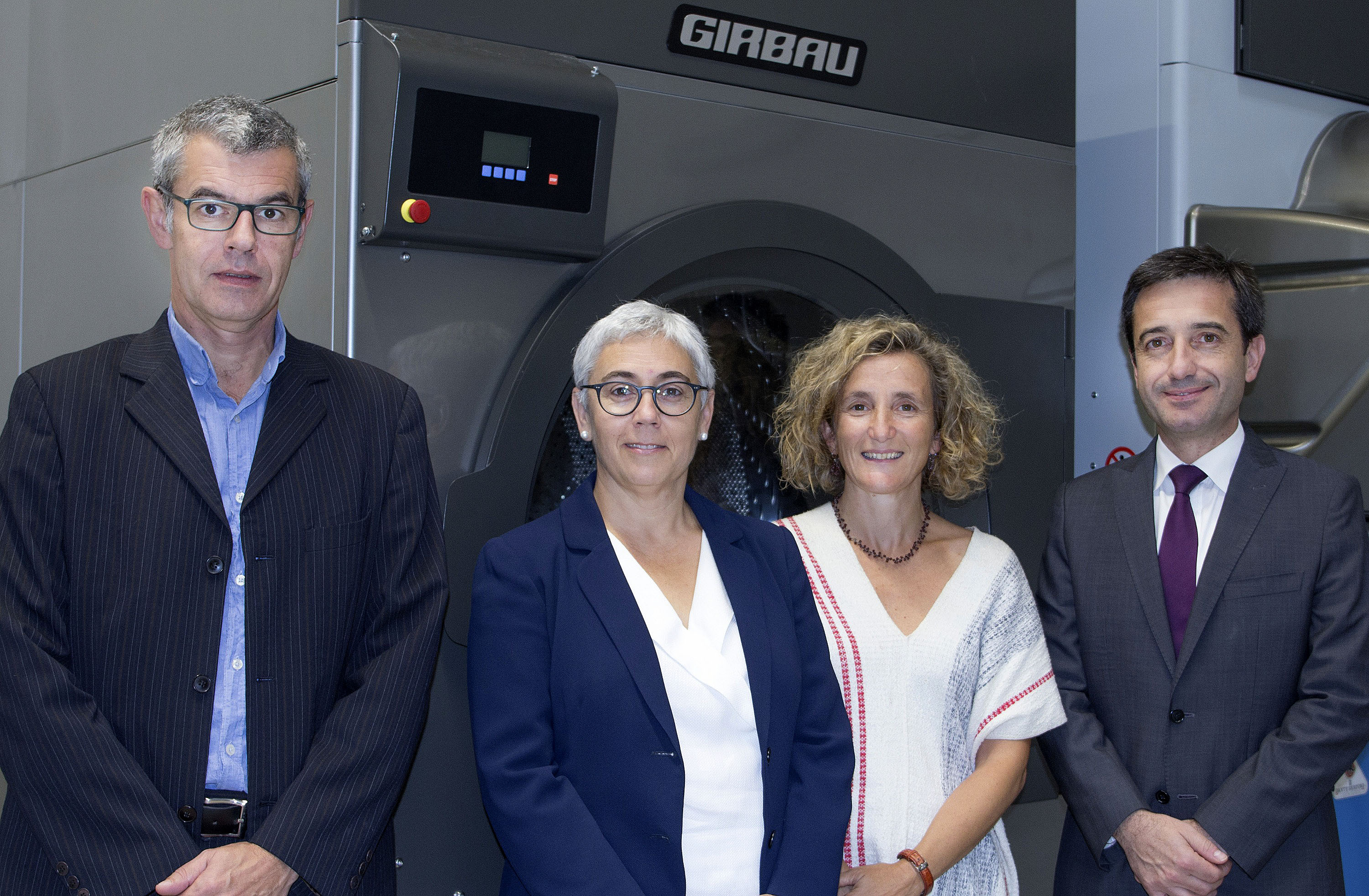 Pere i Mercè Girbau, consellers delegats del grup Girbau, amb Mariona Sanz, responsable d’Innovació, i Guillem Clofent, director general del grup, davant d’una de les màquines de bugaderia que fabriquen
