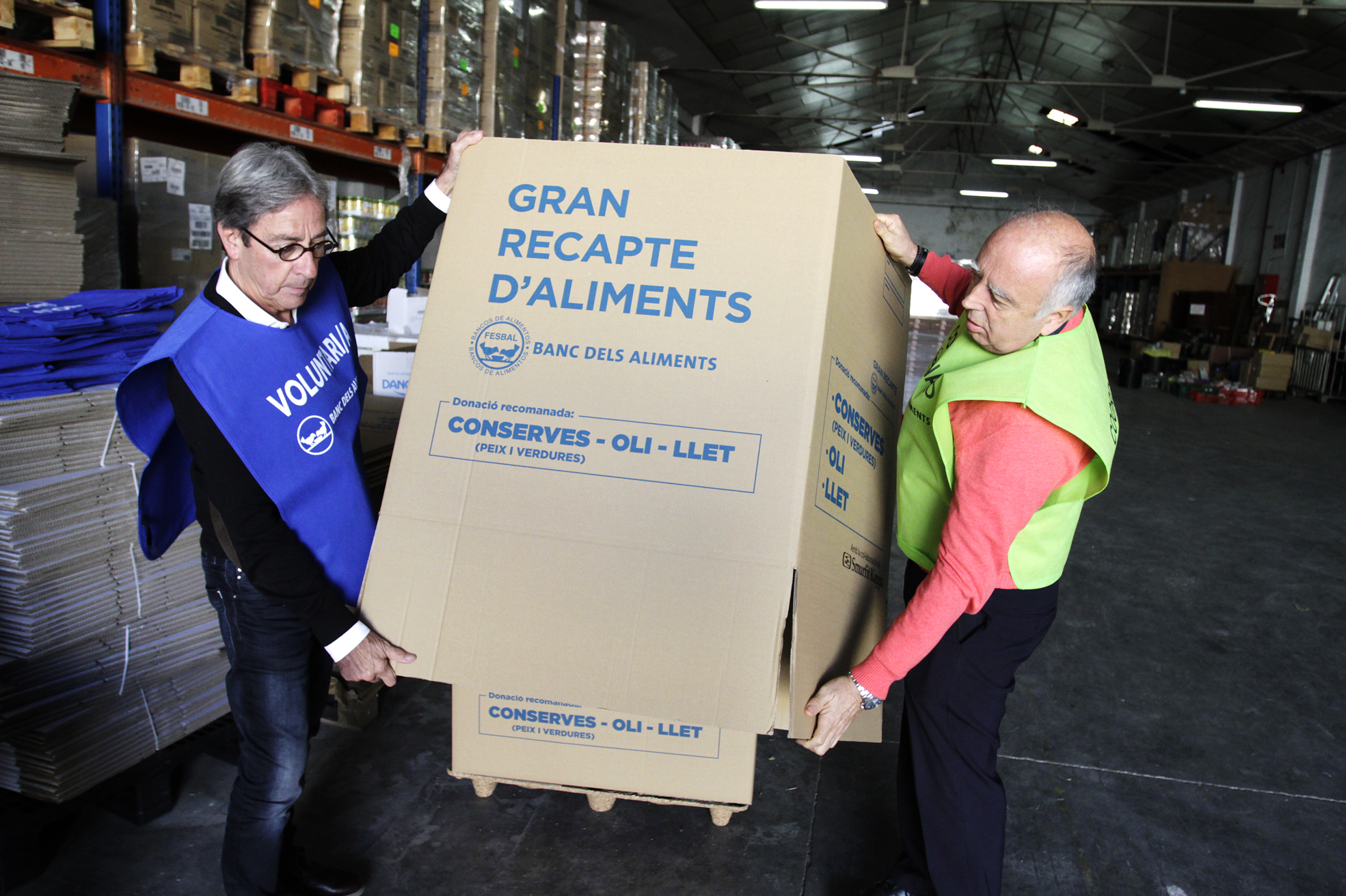 Dos voluntaris preparen les caixes per recollir les donacions al magatzem d'El Xiprer, a les Franqueses
