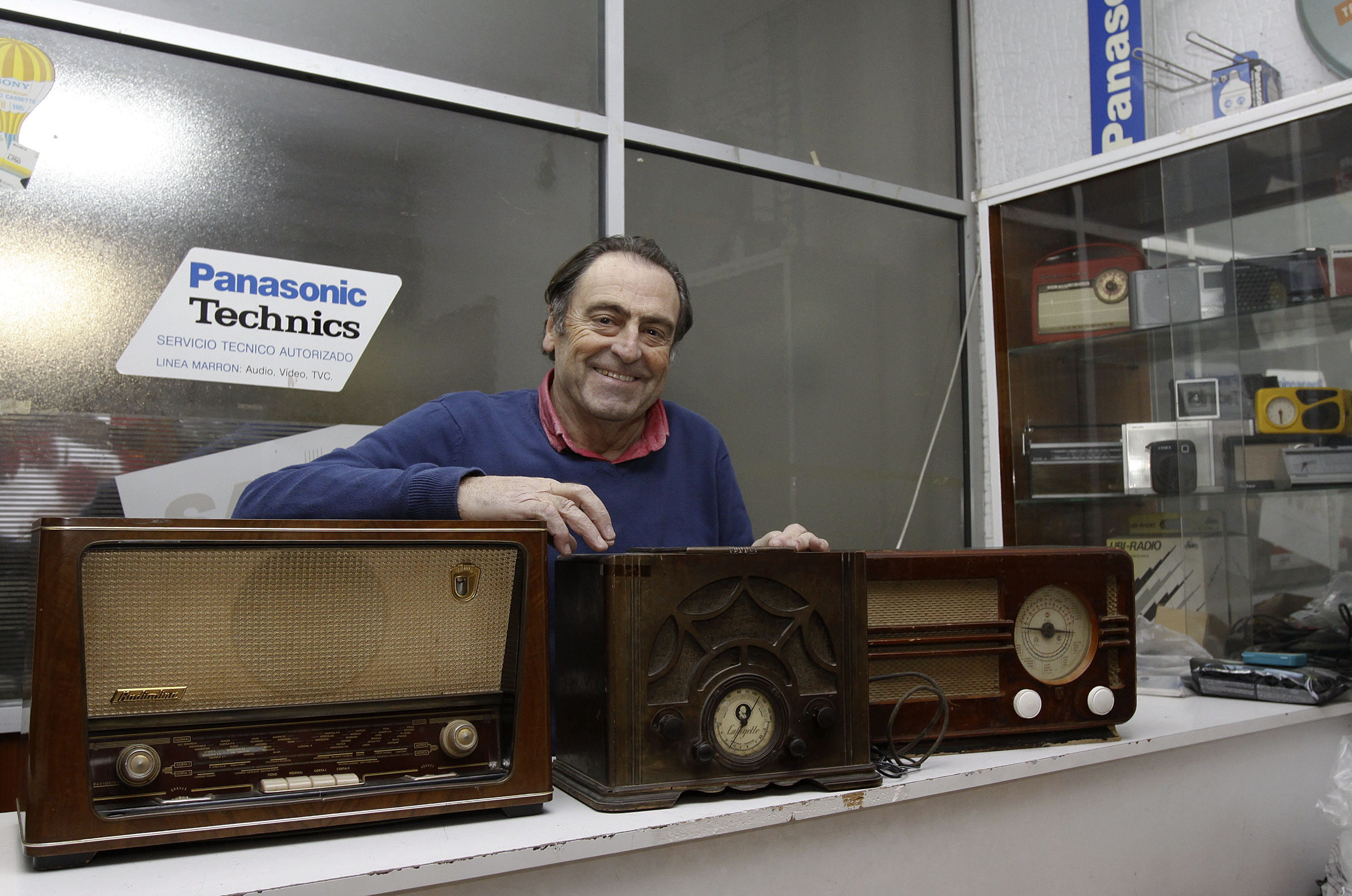 Toni Pla, amb alguns dels aparells històrics que conserva al seu taller. El del mig, per exemple, és una ràdio Lafayette fabricada l’any 1931 a Nova York