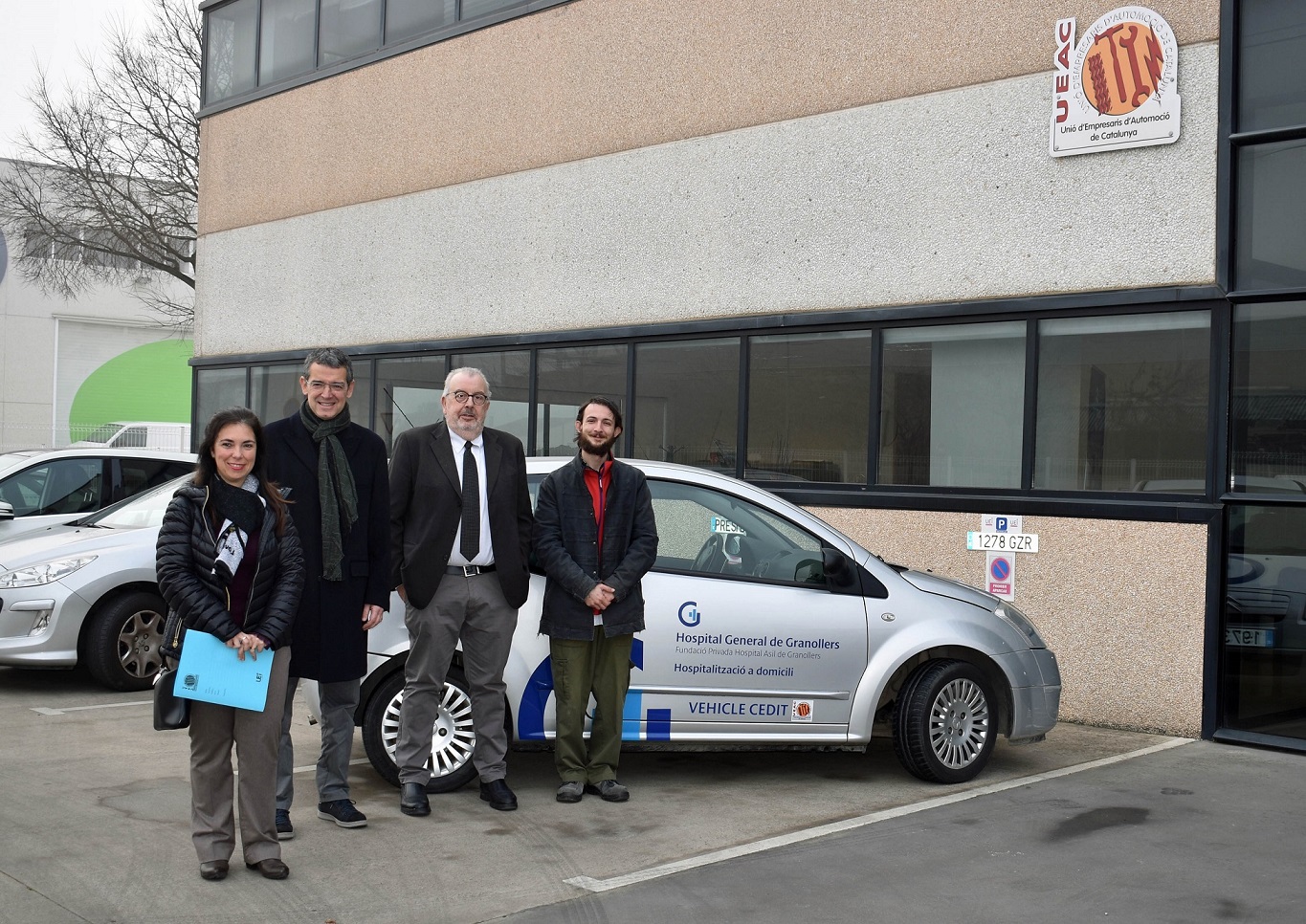 Representants de l'Hospital i de la UEAC amb el vehicle que ha cedit l'organització empresarial