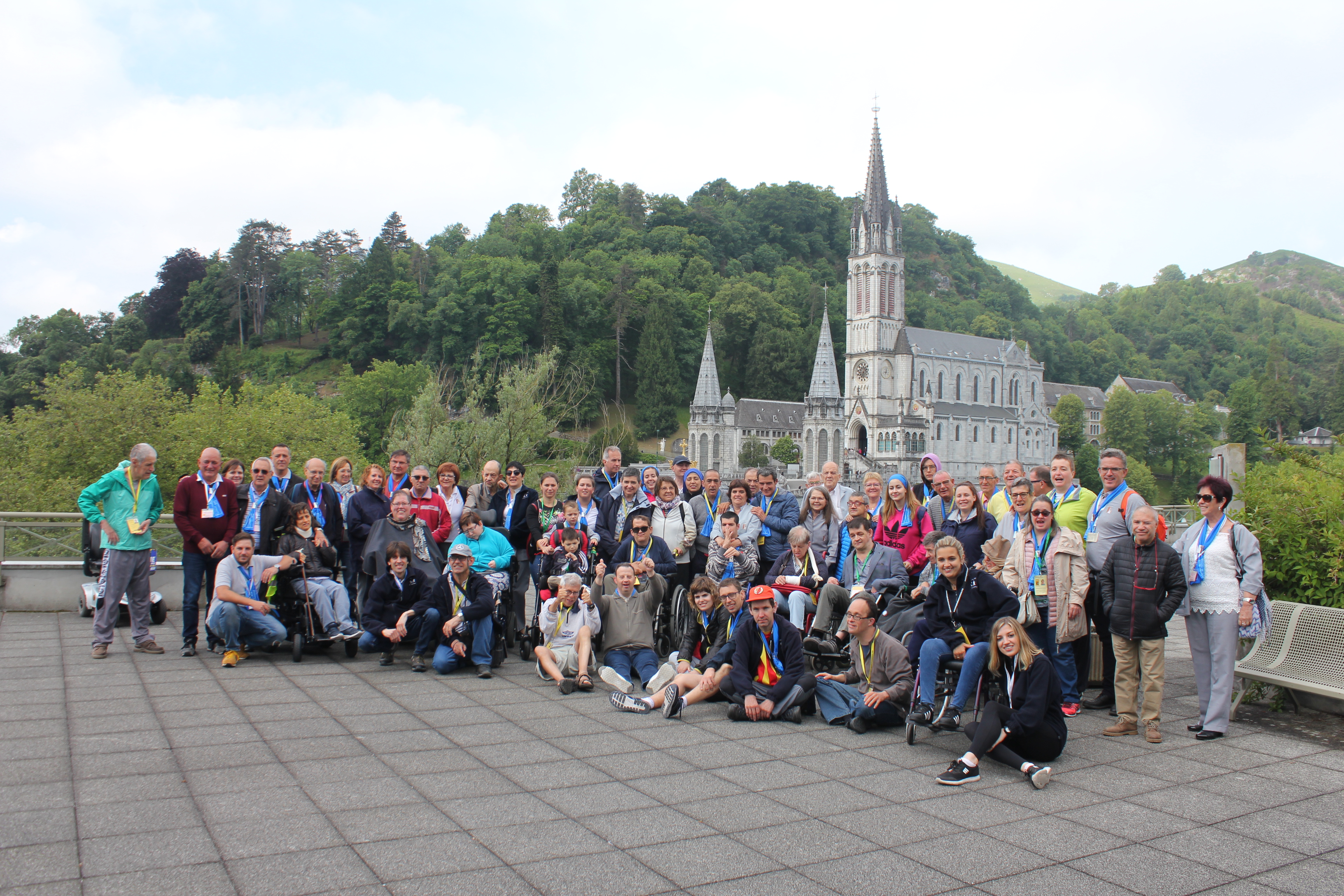 Els participants al pelegrnatge amb la basílica de Lourdes de fons