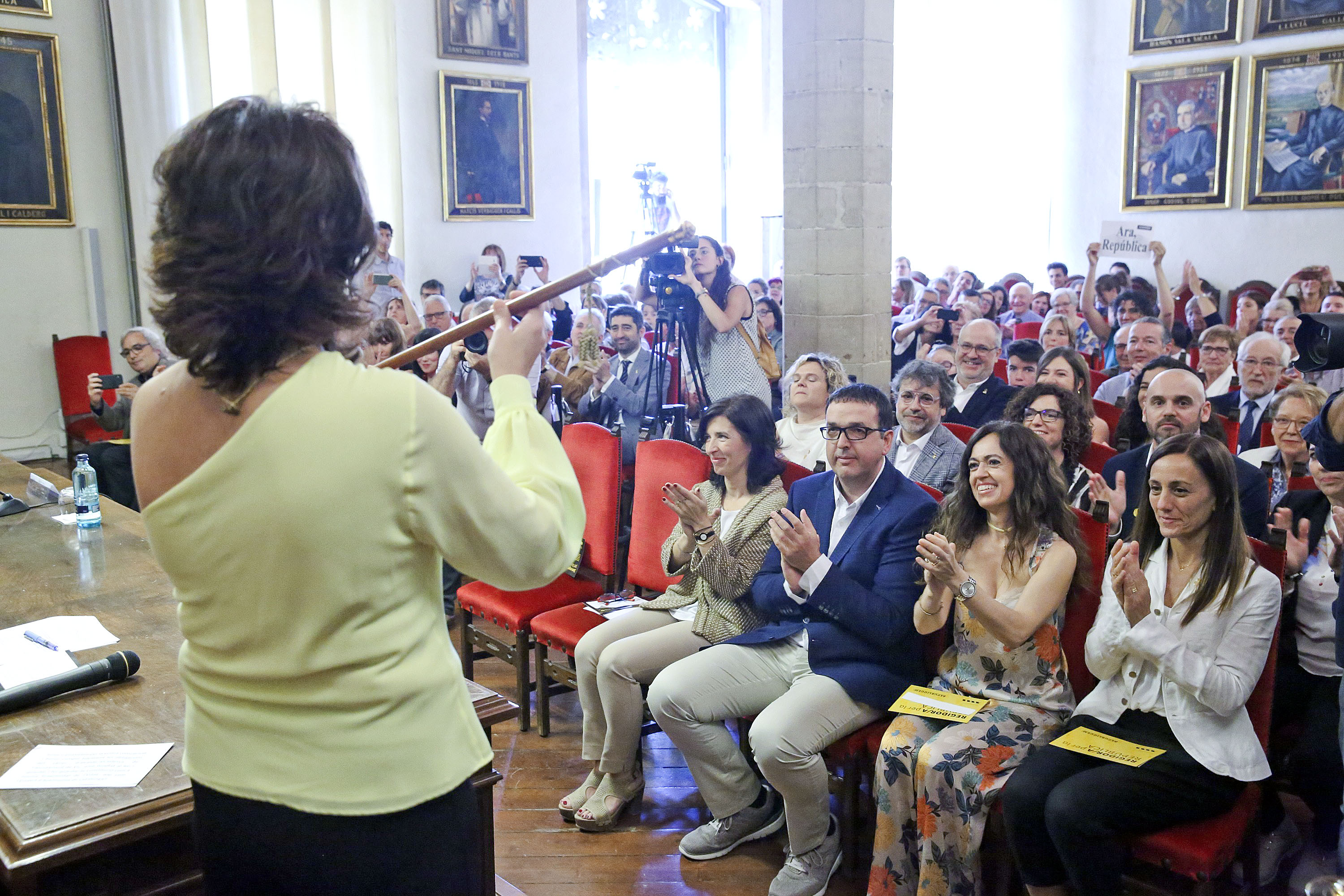 Anna Erra, un cop investida alcaldessa mostra la vara al públic que omplia la Sala de la Columna