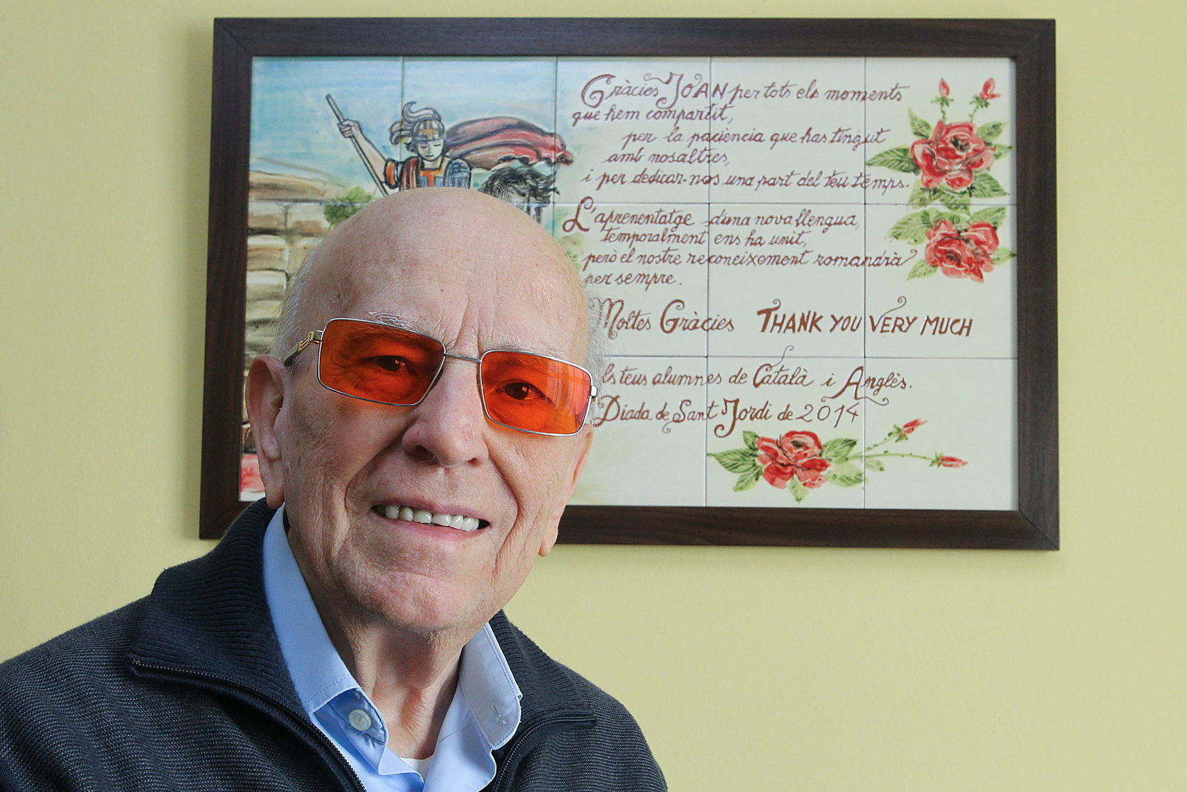 Joan Torrentgenerós davant el quadre que li van regalar pels anys que ha fet classes al casal de la gent gran. La foto és de 2014