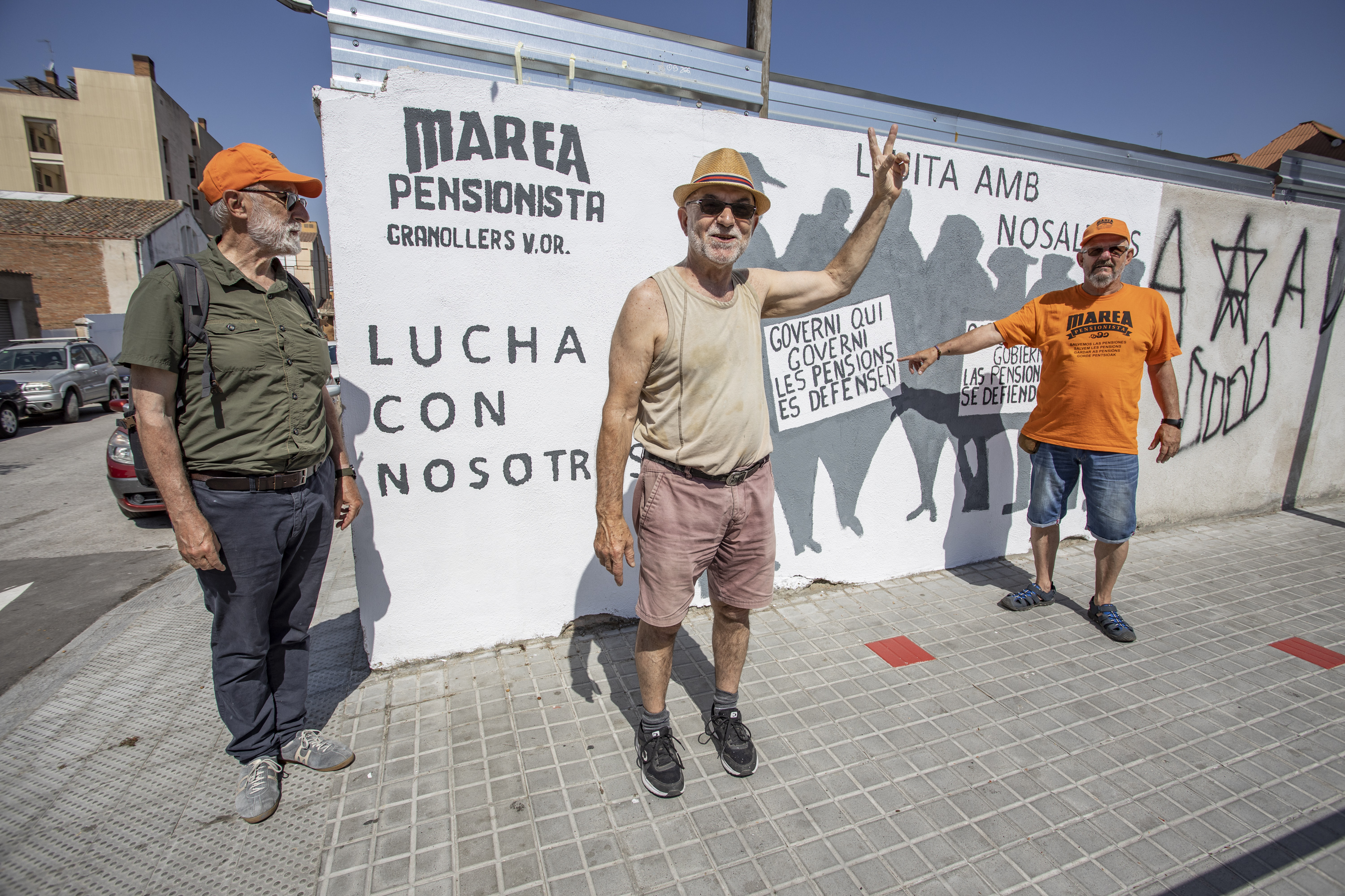 Membres de la Marea Pensionista amb el mural que han pintat aquest dissabte