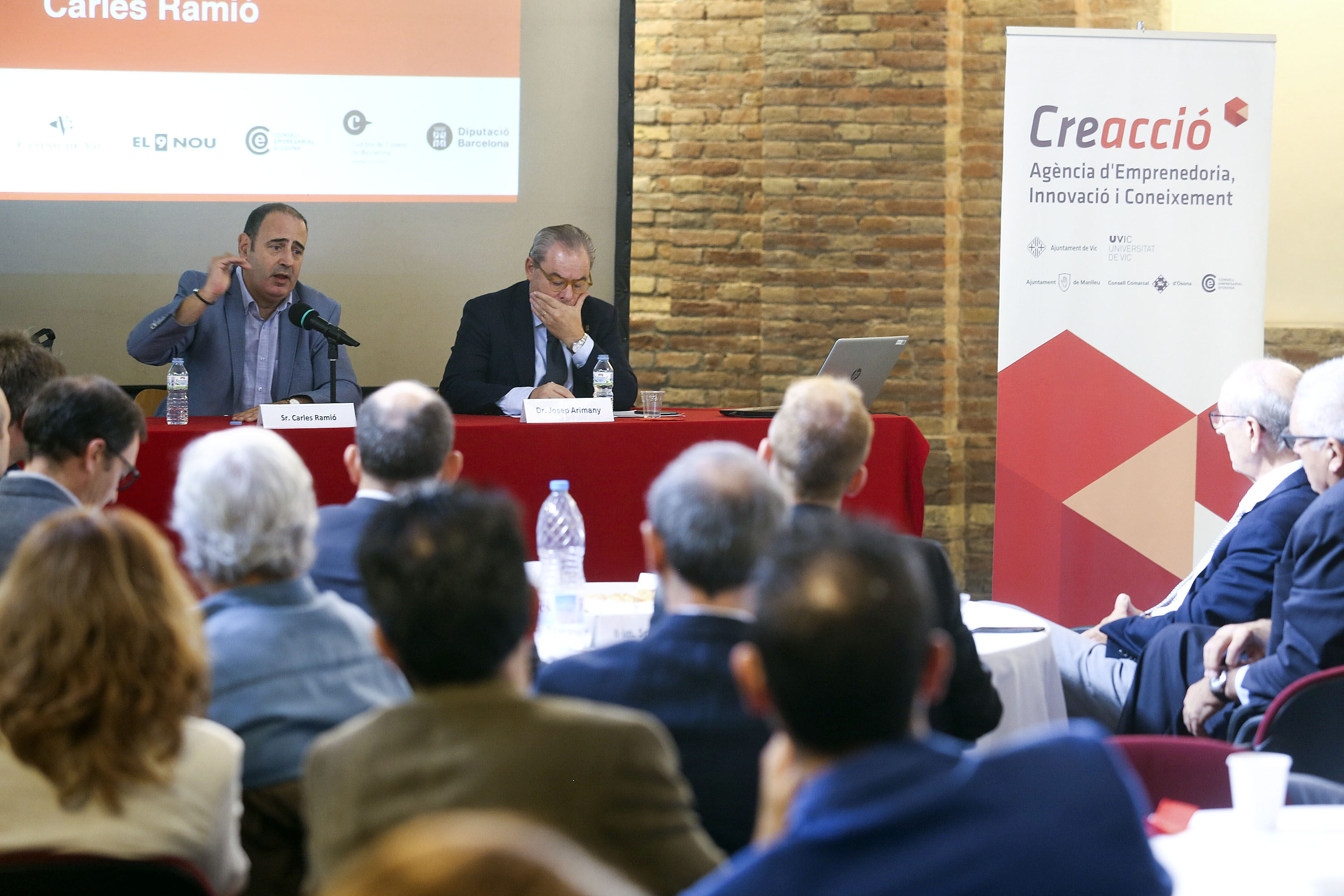 Carles Ramió, parlant, amb Josep Arimany, president de Creacció, que el va presentar a l’Àgora d’Opinió