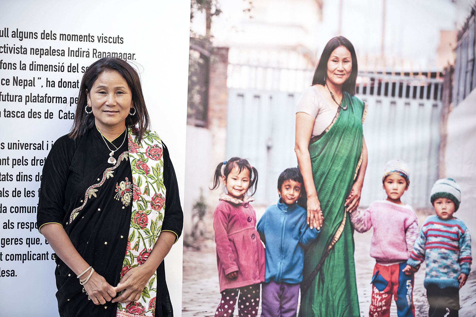 Indira Ranamagar davant d’un plafó informatiu de les activitats que realitza Prisoners Assistance Nepal