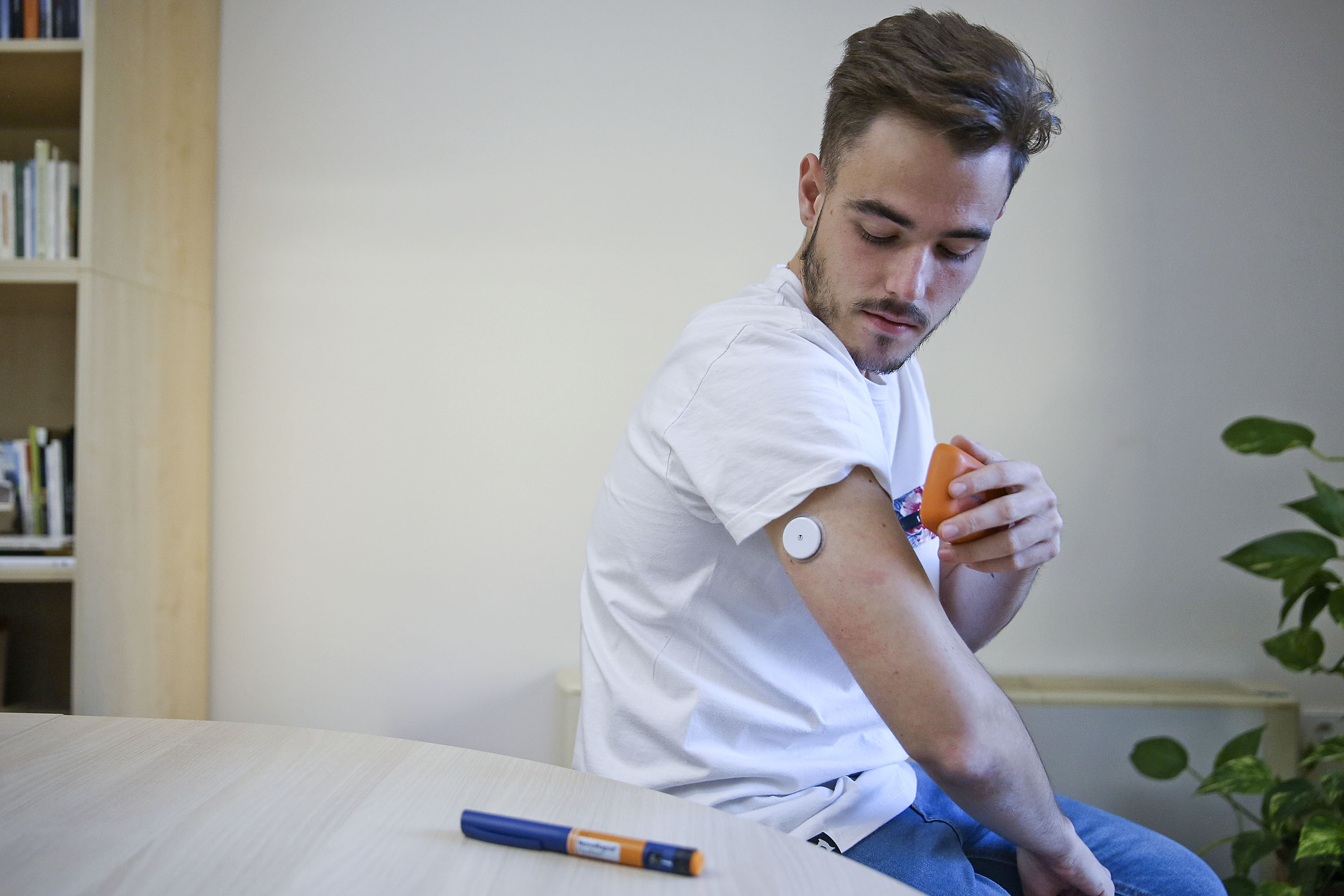 Adrià Millán es passa el glucòmetre sobre el sensor que porta al braç