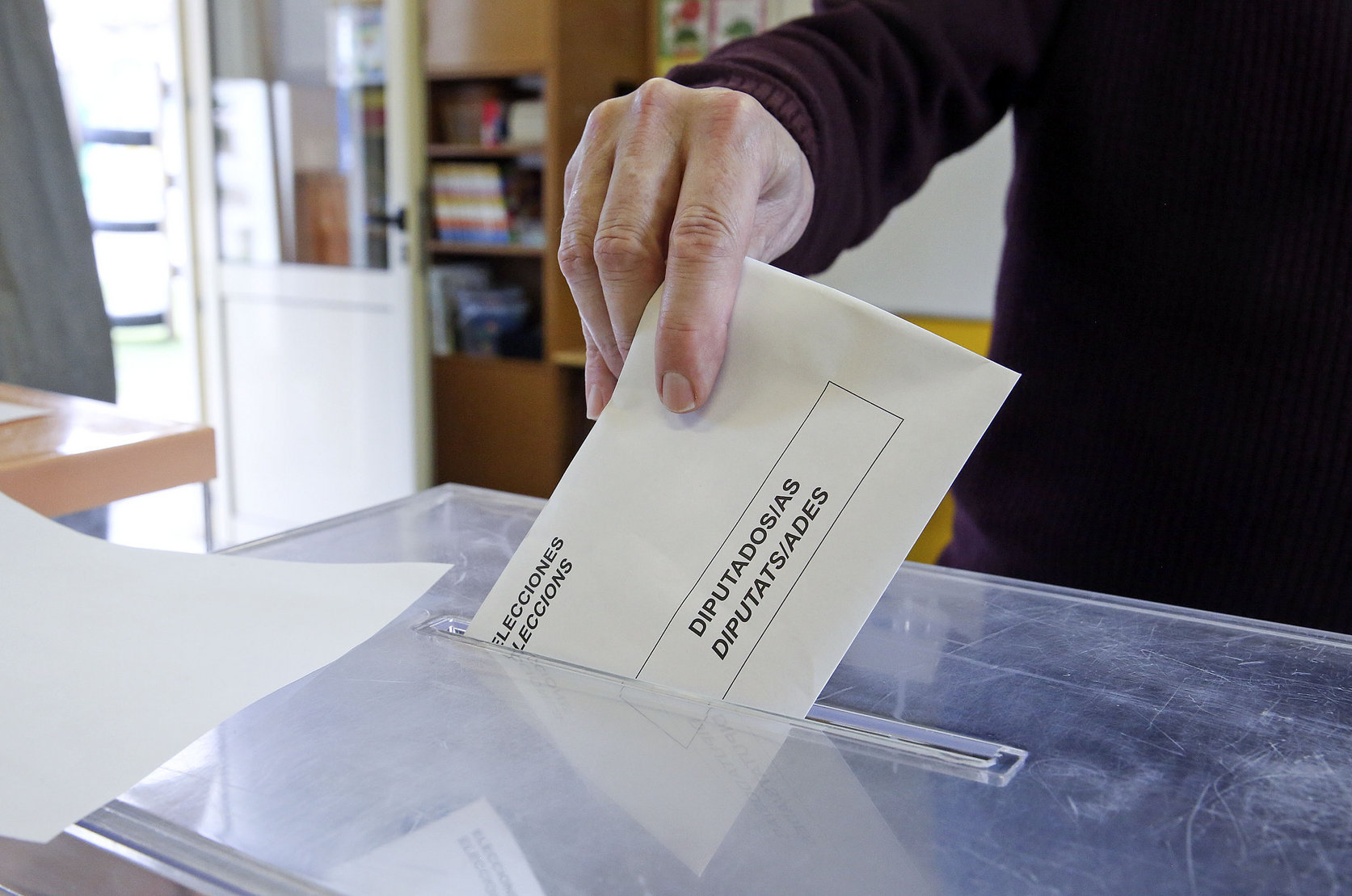 Un votant en el moment de dipositar el sobre a l'urna