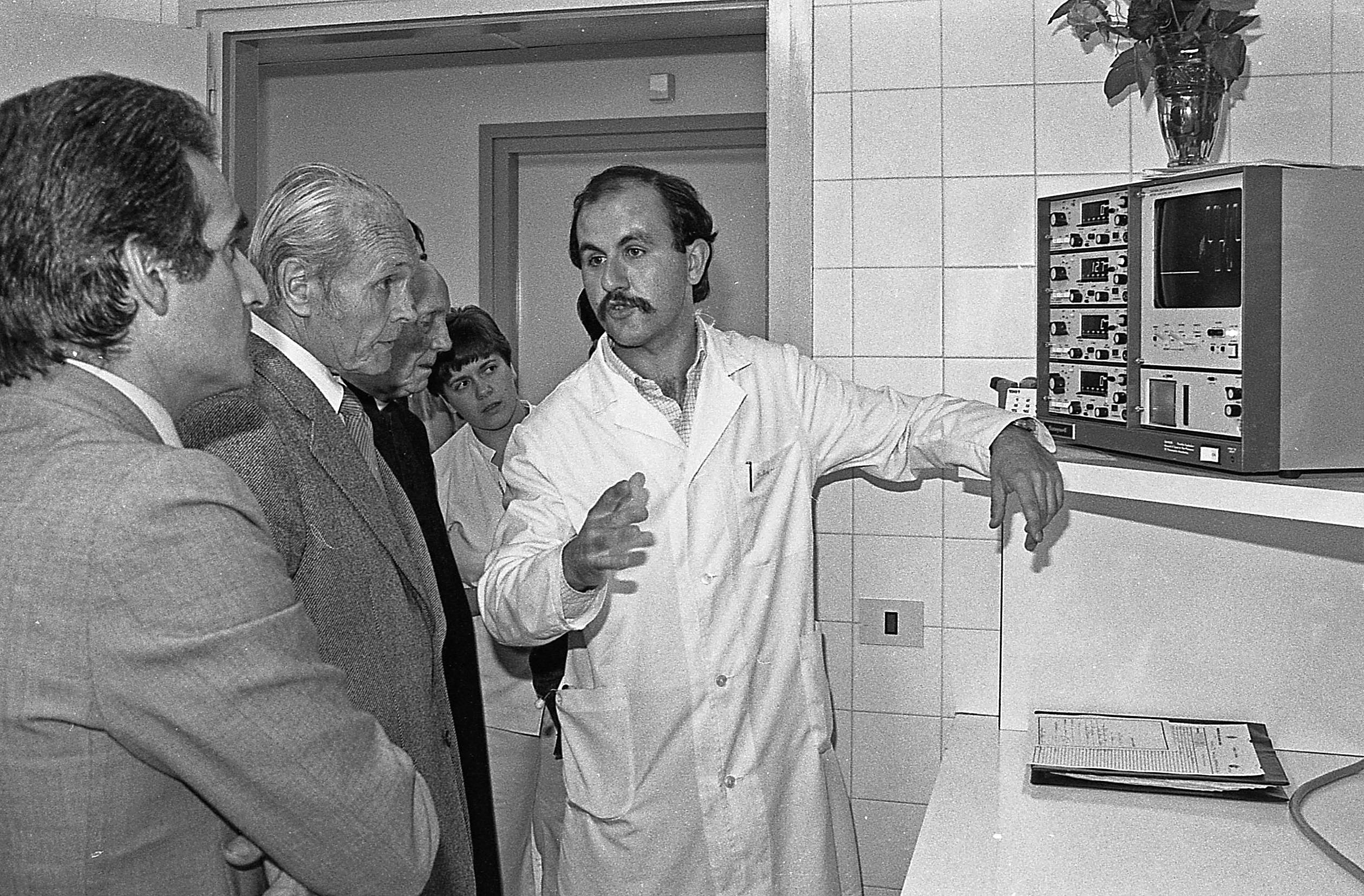 El doctor Rierola escolta les explicacions del doctor Brugués al costat de l'alcalde Montanyà