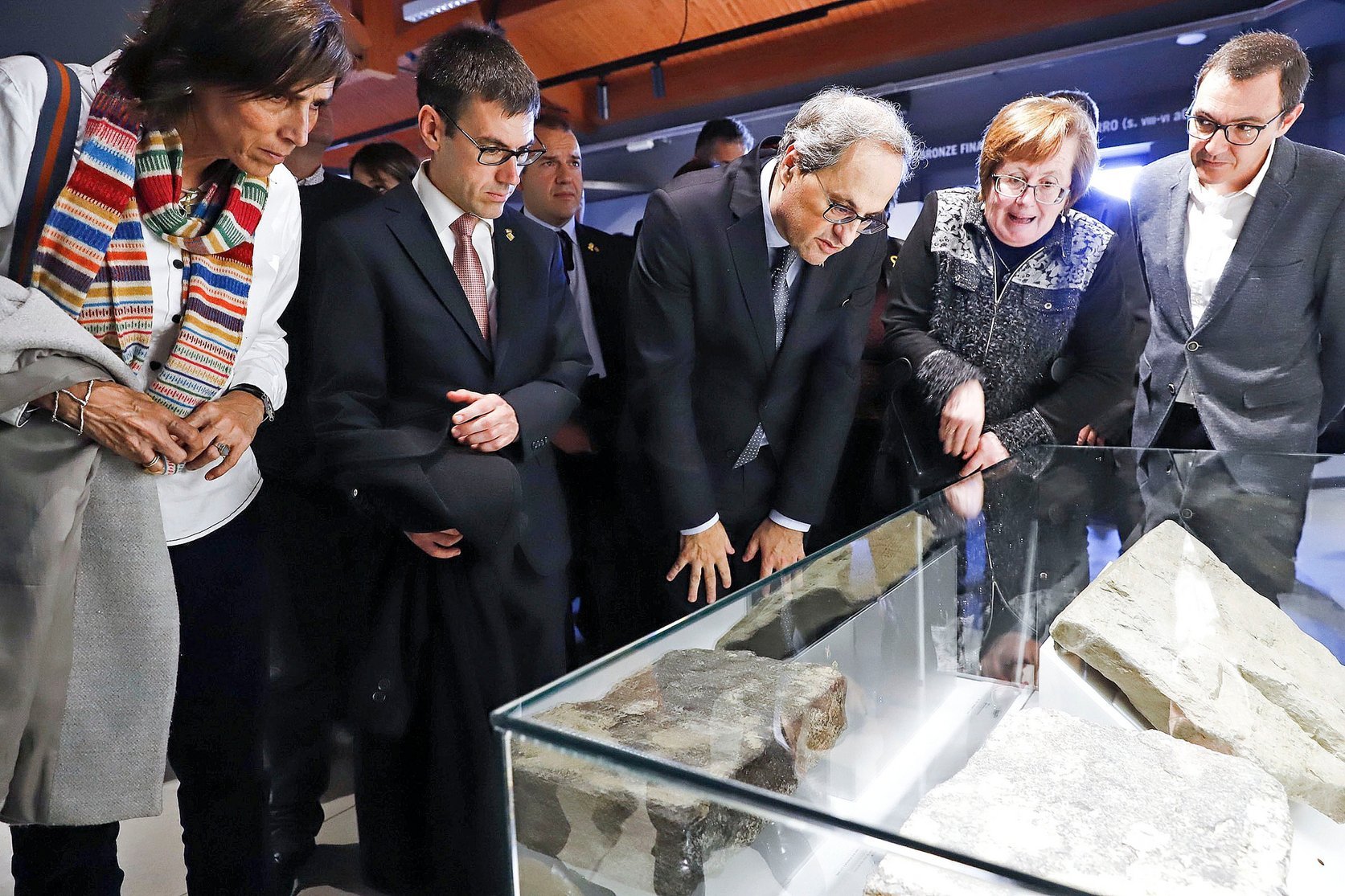 El president de la Generalitat i l'alcalde de Roda, al mig, escolten les explicacions de l'arqueòloga Montserrat de Rocafiguera en el nou museu