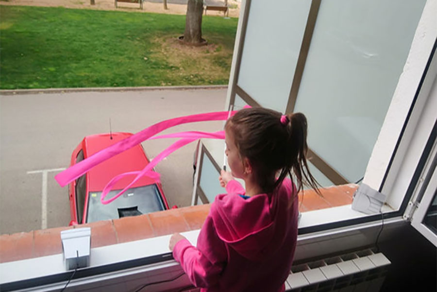Una nena balla una cançó a la finestra de casa seva a Ripoll