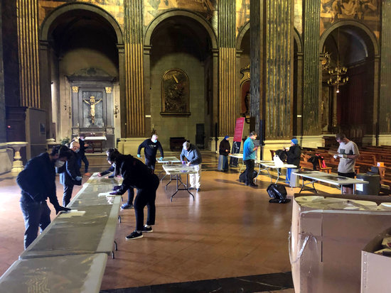 Els voluntaris confeccionant els pantalles protectores a la catedral de Vic