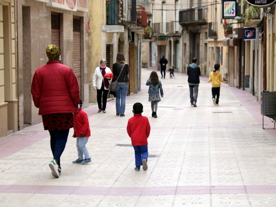 Infants passejant amb els seus pares i mares en un carrer de Cervera