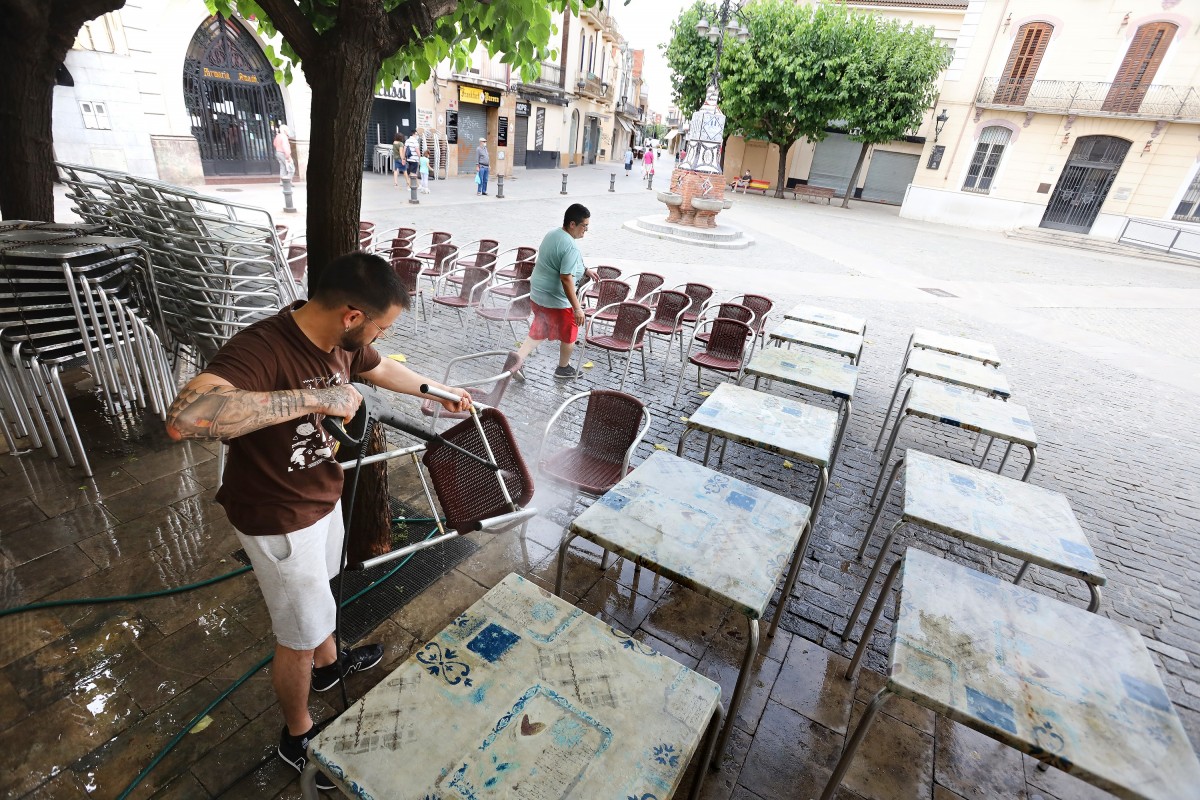Personal del bar La Plaça, de la plaça Prat de la Riba, a Mollet, preparaven les taules per aquest dilluns
