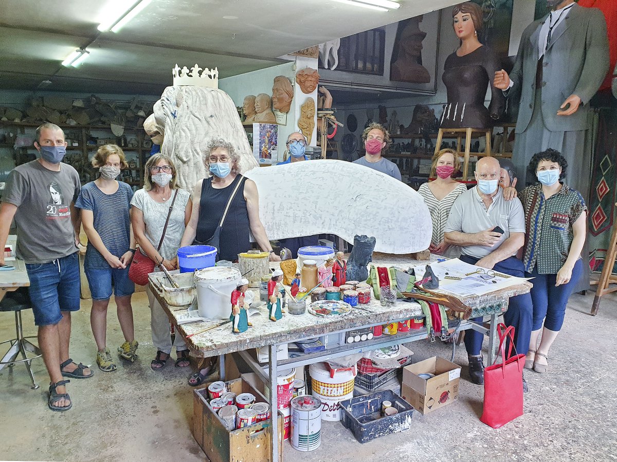 La comitiva vigatana al costat dels artesans que estan construint el lleó, dilluns passat al Taller d'Escultura Casserres de Solsona