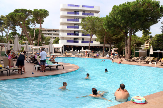 Turistes banyant-se i prenent el sol en una piscina d'un hotel de Salou