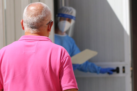 Un home, dirigint-se a un mòdul habilitat al CAP Sant Pere de Reus on l'espera una sanitària per fer-li la prova PCR