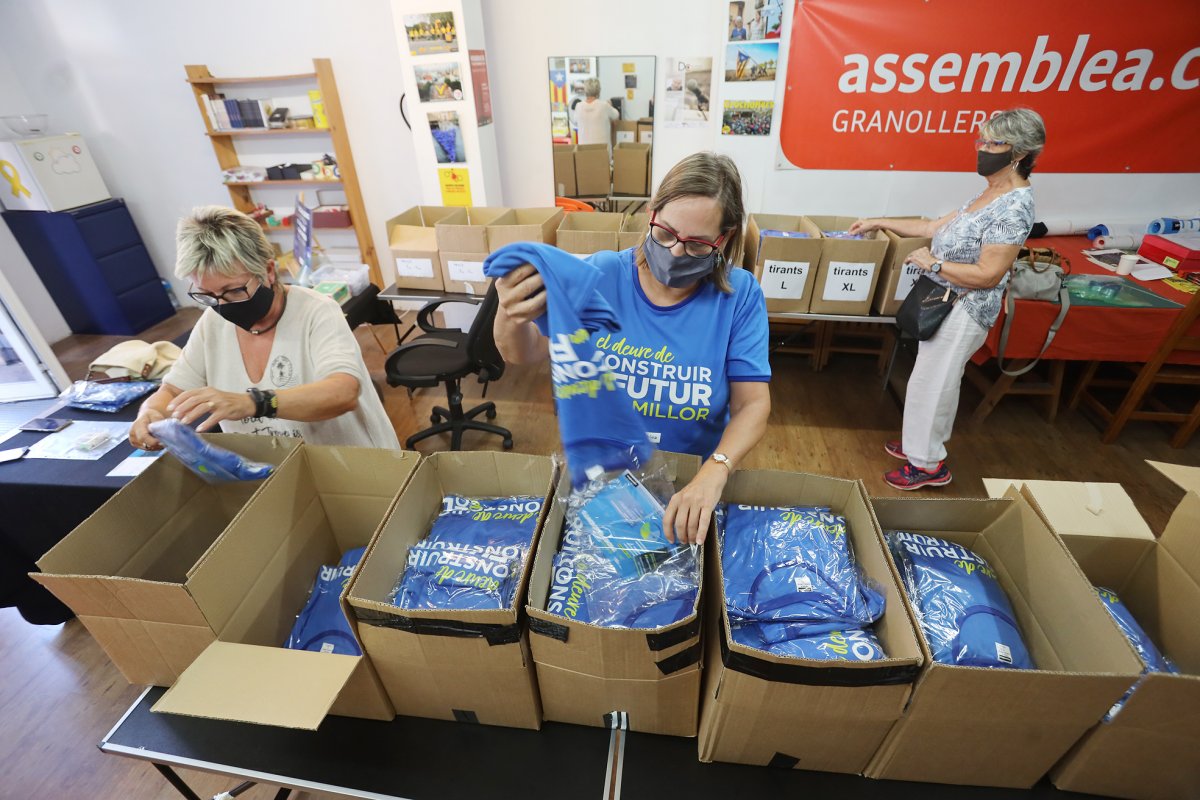 Voluntàries de l'ANC preparen caixes amb les samarretes de la Diada