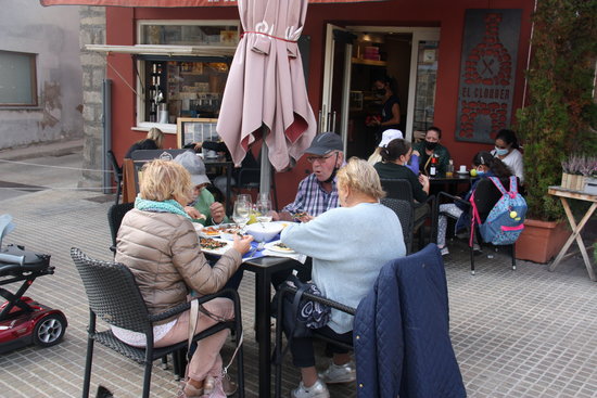 Diverses persones a les taules d'una terrassa de bar en una imatge d'arxiu