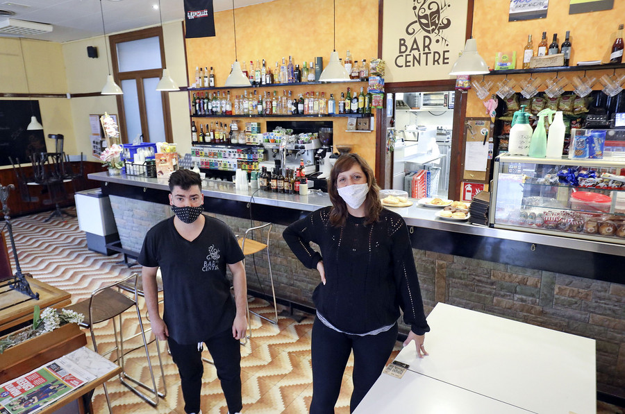Maria del Mar Torres i Marc Molina, un cambrer, al Bar Centre de Sant Joan, que ara no pot atendre clients al local