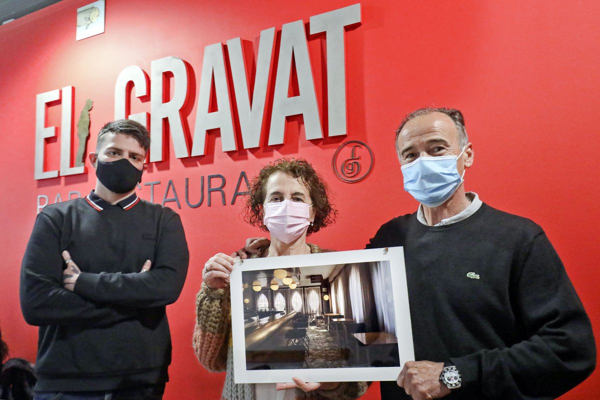 El fotògraf Carles Palacio, amb Conxi Pujol i Joan Casellas mostrant una de les fotos, divendres passat