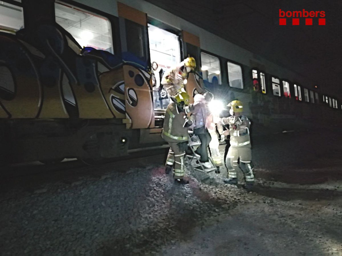 Els bombers, amb una escala ajudant a baixar la gent del tren a l'entrada de Vic