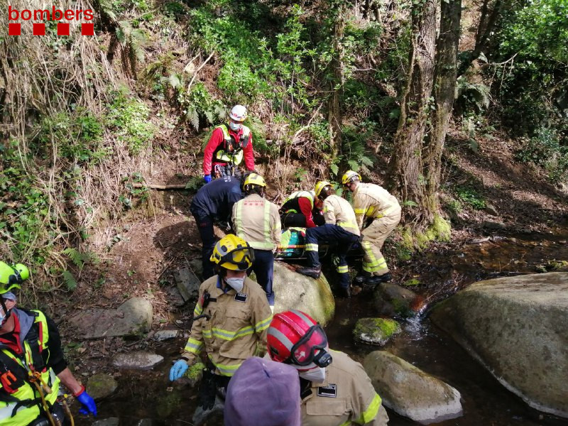 Els bombers treballant a la riera al punt on ha caigut l'operari per un marge de deu metres