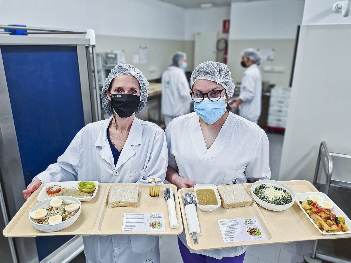 Professionals de Cuina i Infermeria de l'hospital, amb la safata dels menús que porten a les habitacions