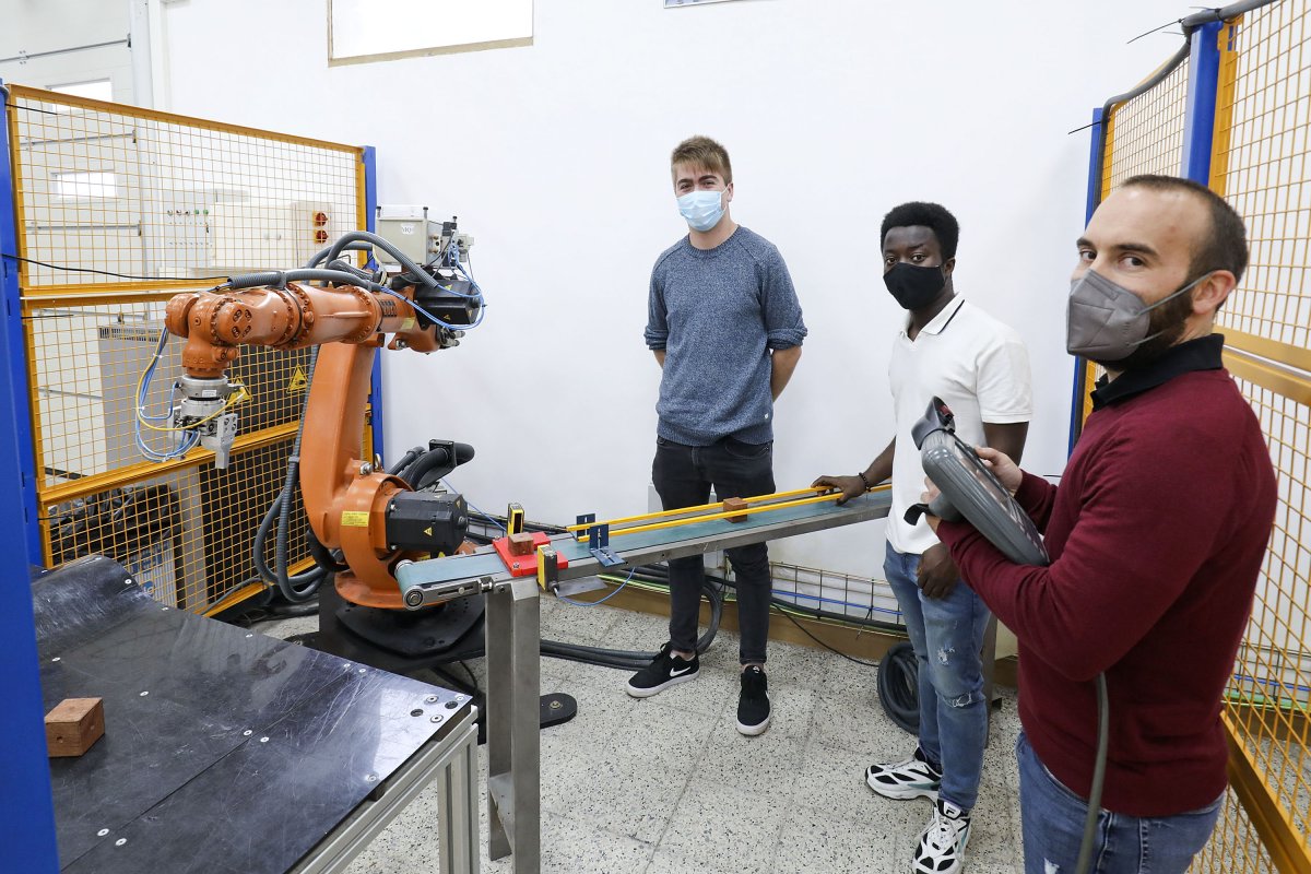 D’esquerra a dreta, Eloi Bertrans, Prince Osei i Eduard Clota amb un dels robots que hi ha a La Salle