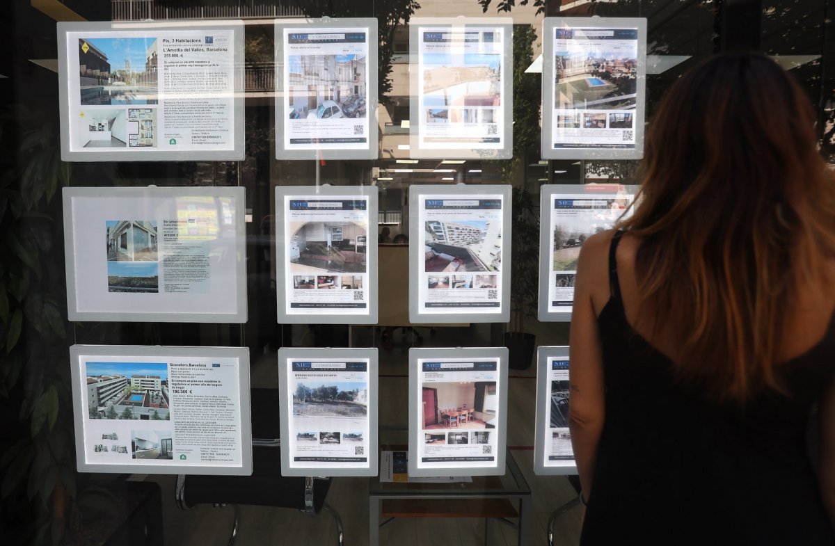 Una persona mira les ofertes d'una immobiliària en una imatge d'arxiu